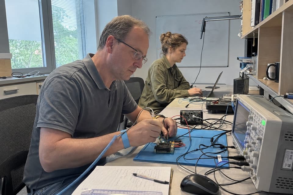 Illustrative scene of developers testing an embedded board with bench instruments